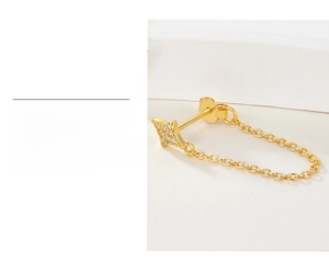 Close-up of gold-plated star earrings with zircon inlay and elegant chain detail