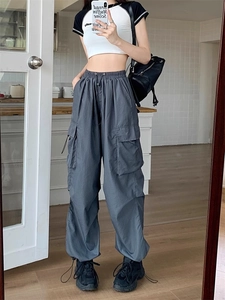 Detail view of dark grey wide-leg cargo pants with elastic waist and adjustable hems