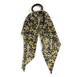Detail of floral printed ribbon hair tie with white pearl accent on black elastic band