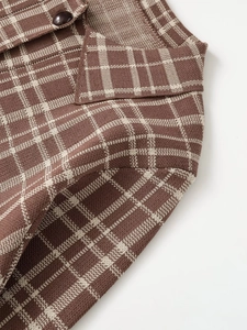 Close-up detail of the plaid knit cardigan showing brown lapel and fine fabric texture