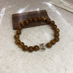 Gros plan détaillé de perles d'ambre et pendentif croix en argent sur toile et fond de bois