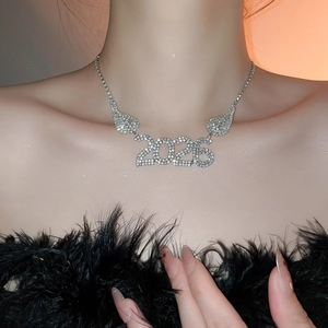 Dettaglio della collana d'argento 2026 con ciondolo alato e strass scintillanti su modella
