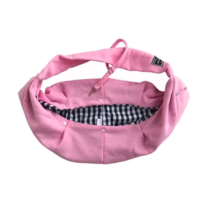 Pink pet sling bag with black and white checkered lining and adjustable strap detail