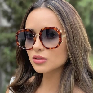 Oversized polygon tortoiseshell sunglasses with dark gradient lenses and gold metal temples