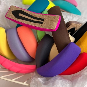 Close-up of vibrant colorful fabric hair clips displayed in a white metal wire basket