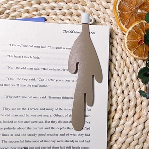 Close-up of light brown leather spilled coffee bookmark inside an open vintage book
