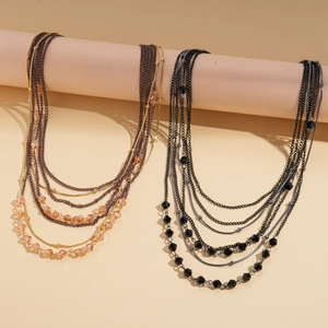 Detail of bohemian layered beaded necklaces in brown gold and black silver finishes