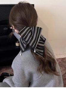 Détail d'un chouchou en satin à rayures noires et blanches avec des perles élégantes