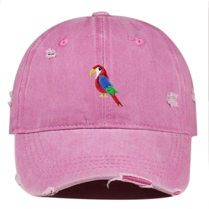 Distressed pink baseball cap featuring colorful parrot embroidery and vintage wash details