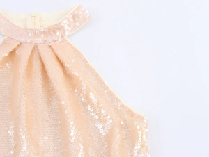 Detail of champagne sequin party dress showing halter neck pleats and shimmery fabric