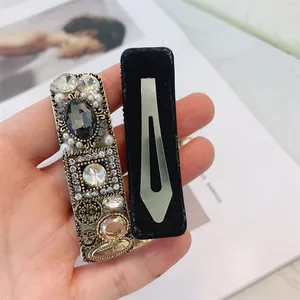 Close-up of a velvet-backed hair clip with sparkling crystals and pearls decoration