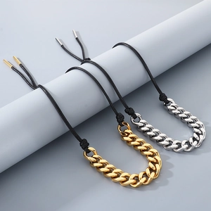 Detail of 13mm stainless steel Cuban chain bracelets with black cord on display