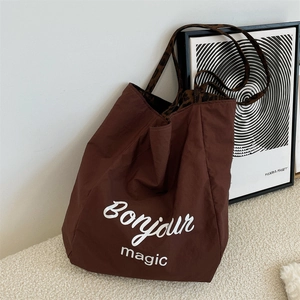 Detail of leopard print straps and Bonjour magic print on a large brown canvas tote bag