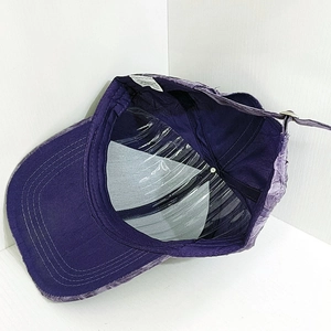 Detail of purple breathable baseball cap interior with stitching and inner labels