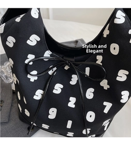 Detail of canvas bucket bag featuring bold numerical print and elegant black drawstring bow