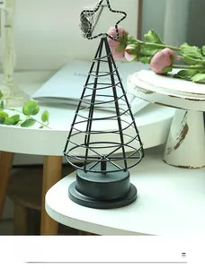 Detail of Nordic black iron cone tree lamp with LED fairy lights and star topper