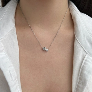 Close-up of elegant double heart pear-shaped zircon pendant necklace on woman neck