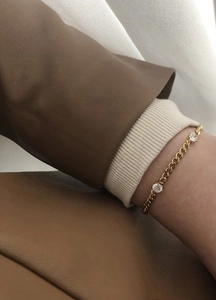 Detail of 18K gold-plated chain bracelet with round zircon stones on female wrist