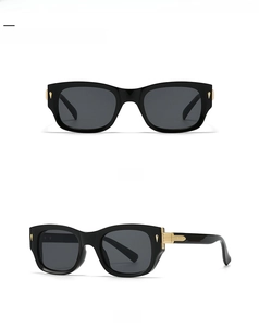 Detail view showing black and gold pilot sunglasses with metal accents and square frame