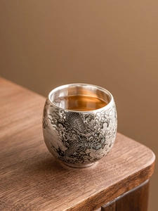 Gros plan détaillé du motif de dragon gravé sur une tasse à thé doublée d'argent 999