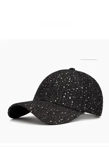 Détail d'une casquette noire avec motif d'éclaboussures blanches et design classique à six pans