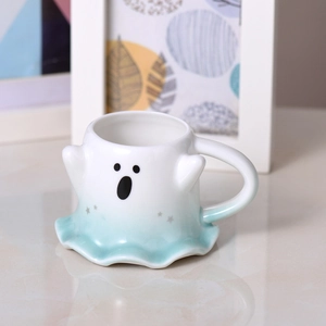 Detailed close-up of ghost-shaped ceramic mug with blue wavy base and cute star pattern