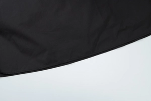 Nahaufnahme der schwarzen Stofftextur und professionellen Saumnähte am Kleid