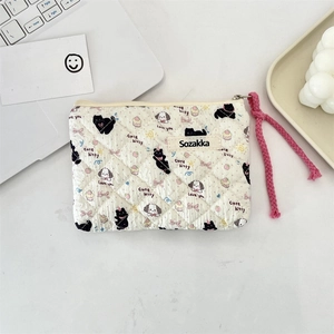 Close-up of quilted floral cosmetic pouch featuring cute cartoon cat and dog patterns