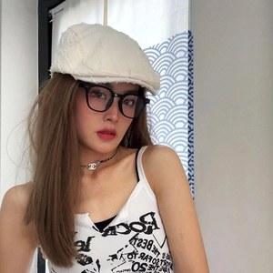 Vue détaillée d'une casquette plate blanche effilochée portée par un mannequin élégant
