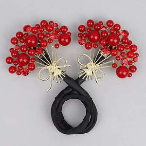 Détail de cristaux de zircon rouges et perles sur pince à cheveux papillon élégante