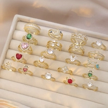 Macro display of assorted gold rings with colorful gemstones in a beige velvet tray