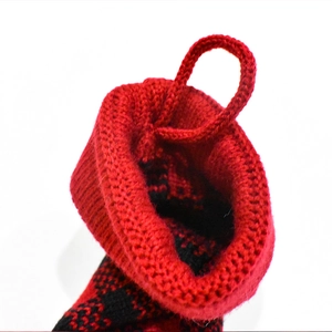 Close-up of a red and black knitted Christmas stocking with a durable hanging loop