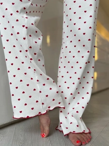 Detail of white pajama pants with red heart print and ruffled wavy hem edges