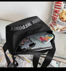 Vue intérieure du sac bandoulière en nylon noir montrant sa grande capacité de rangement