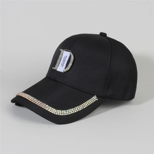 Close-up of sparkling rhinestone D-logo and crystal-embellished brim on black denim cap