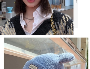Detail of light blue textured knit hat with BAODIDUO patch and winter apparel