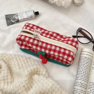 Detail of red and white checkered knit pouch with handmade crochet cherry charms