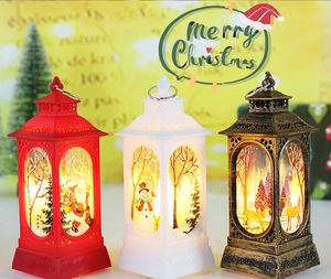 Three Christmas lanterns in red, white, and bronze featuring Santa, snowman, and reindeer art