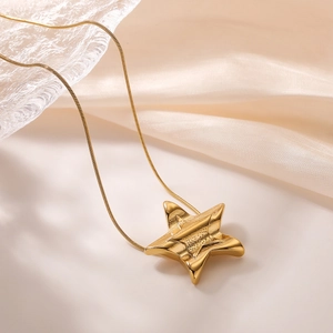 18K gold plated necklace featuring a 3D star pendant over elegant silk background