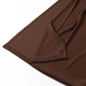 Detailed macro view of dark brown knitted fabric with subtle glitter and overlock stitching