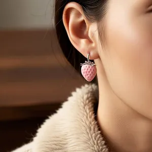 Sweet pink strawberry drop earrings worn by an Asian model in a cozy beige sweater.