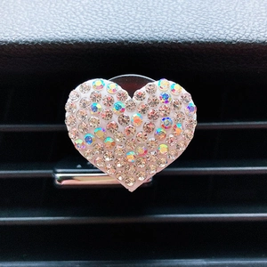 Close-up of heart-shaped rhinestone car vent clip decoration with colorful crystals