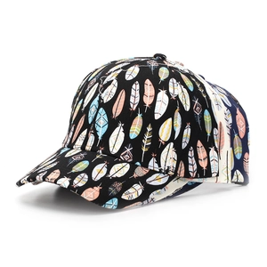 Close-up of stacked baseball caps with colorful feather prints on black fabric