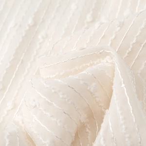 Macro shot of apricot fabric with fine silver threads and textured jacquard dots