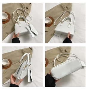 Detail view of white crocodile pattern shell bag with mini pouch and adjustable strap