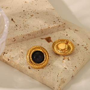 Détail de boucles d'oreilles martelées dorées avec grès bleu et texture vintage