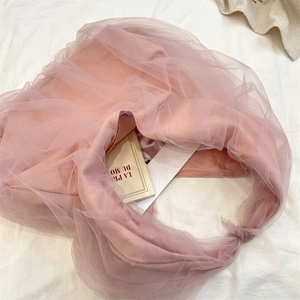 Detail view of pink mesh cloud bag featuring soft ruffled tulle and side knot accents