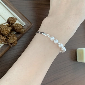 Detail of 925 sterling silver pearl bracelet on wrist with elegant minimalist design