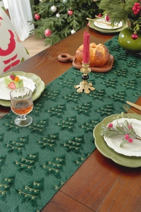 Detail of dark green Christmas table runner with golden embroidered trees and tufted texture