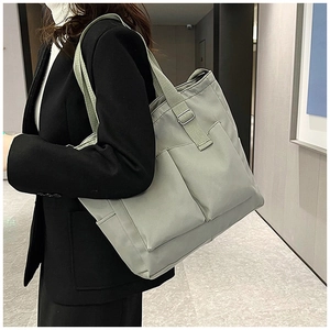 Detail view of water-resistant light green canvas tote bag with multiple pockets